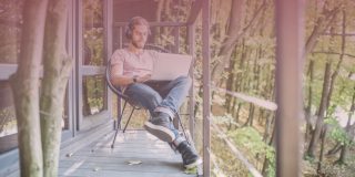 Man sitting outside while using laptop enjoying remote work benefits