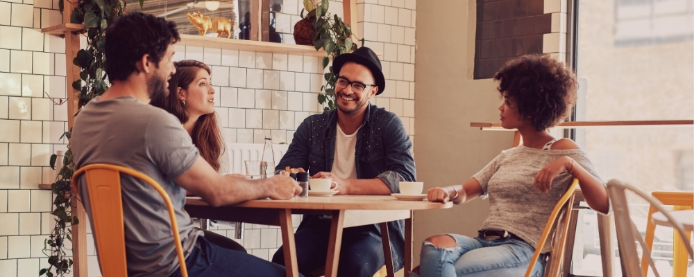 Team members meeting in person at a coffee shop to get to know one another