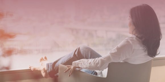 Woman lounging in chair looking out the window relaxing