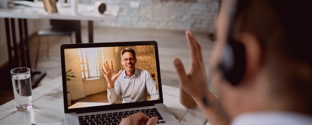 Two male remote employees on a video call to help reach a burnout resolution