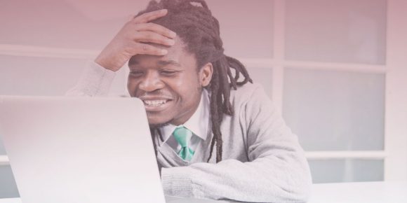 Man reading reading something on his computer and laughing