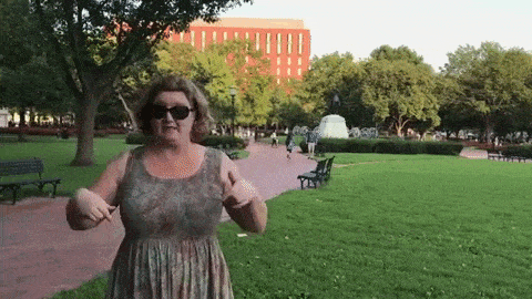 Woman in park pointing down.