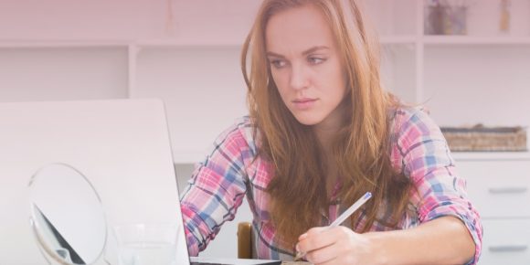 Woman looking at her laptop with an annoyed expression