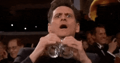 Jim Carrey using glasses as binoculars with a funny face