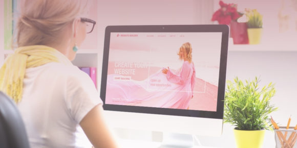 Woman sitting in front of computer customizing her own website to display business values